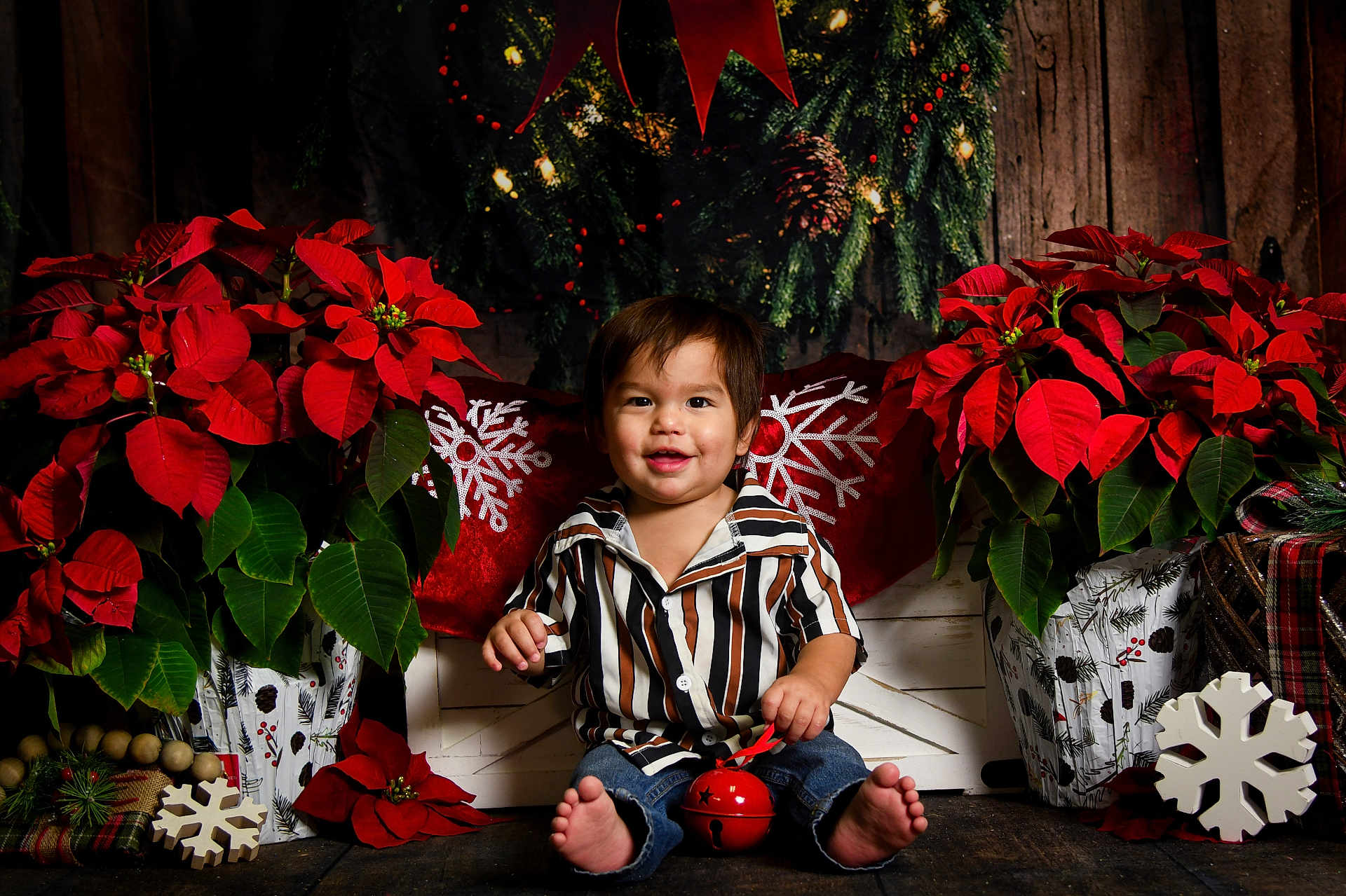 Vincent is registered to the contest to win money with this photo: toddler, child, barefoot, striped_shirt, jeans, red_jingle_bell, poinsettia, christmas_decor, snowflake, holiday, gift_wrapping, wooden_floor, smile, indoor, festive, greenery, red_flowers, cute, sitting, decorative_pillow