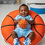 Grayson is registered to the contest to win money with this photo: baby, basketball, bean_bag, blue_outfit, smiling, sneakers, indoor, child, toy, happy, cute, sport, footwear, person, infant, playful, seated, floor, clothing, portrait
