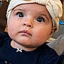 adorable, apparel, baby, bow, child, closeup, clothing, curious, cute, expression, eyes, face, headband, headwear, indoors, infant, person, portrait, soft_lighting, young_child
