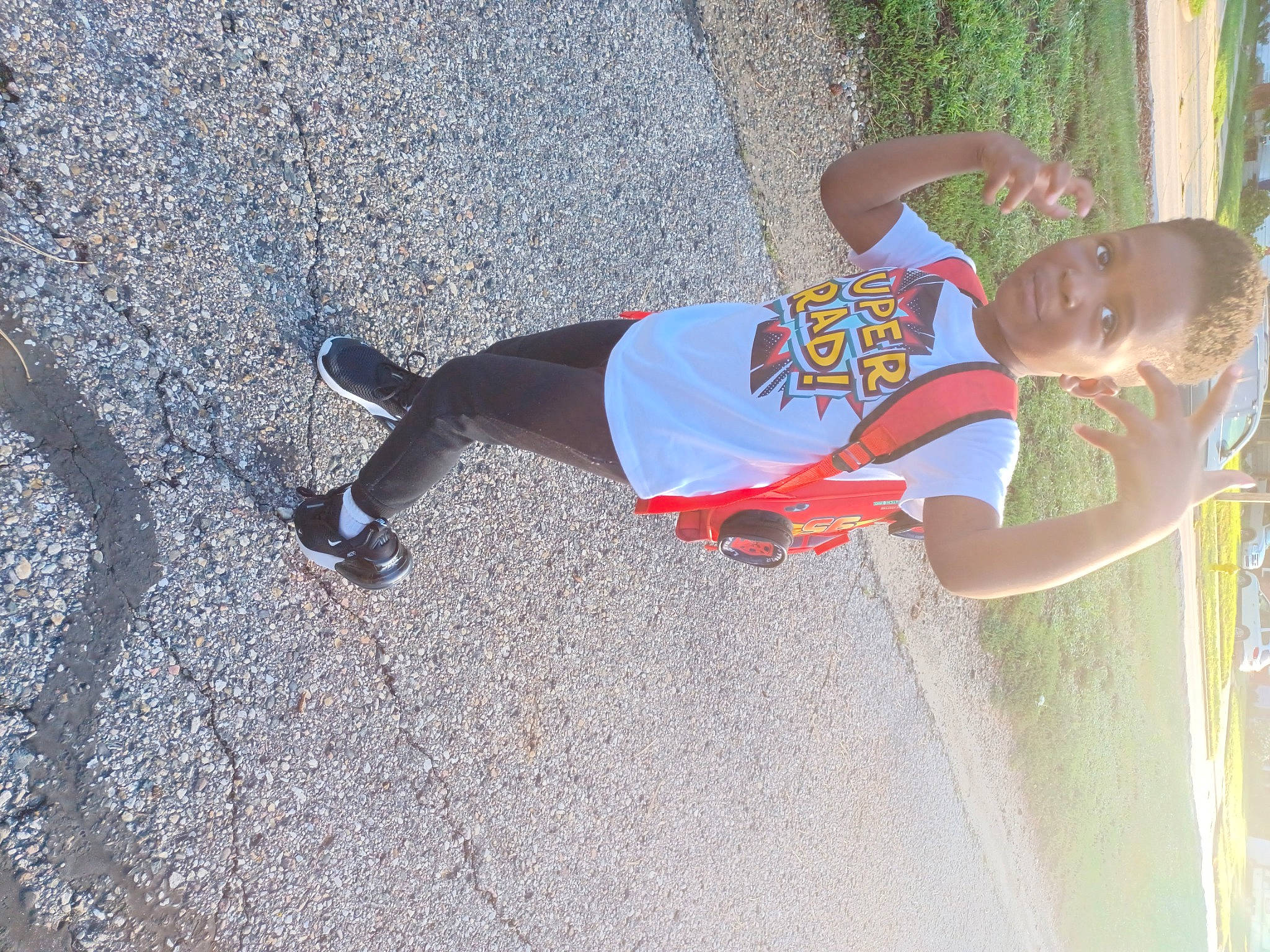 Za'Mir is registered to the contest to win money with this photo: asphalt, electric_blue, fun, human_leg, knee, leisure, pedestrian, person, plant, recreation, road_surface, shadow, shorts, sidewalk, sneakers, sportswear, t_shirt, thigh, toddler, tree