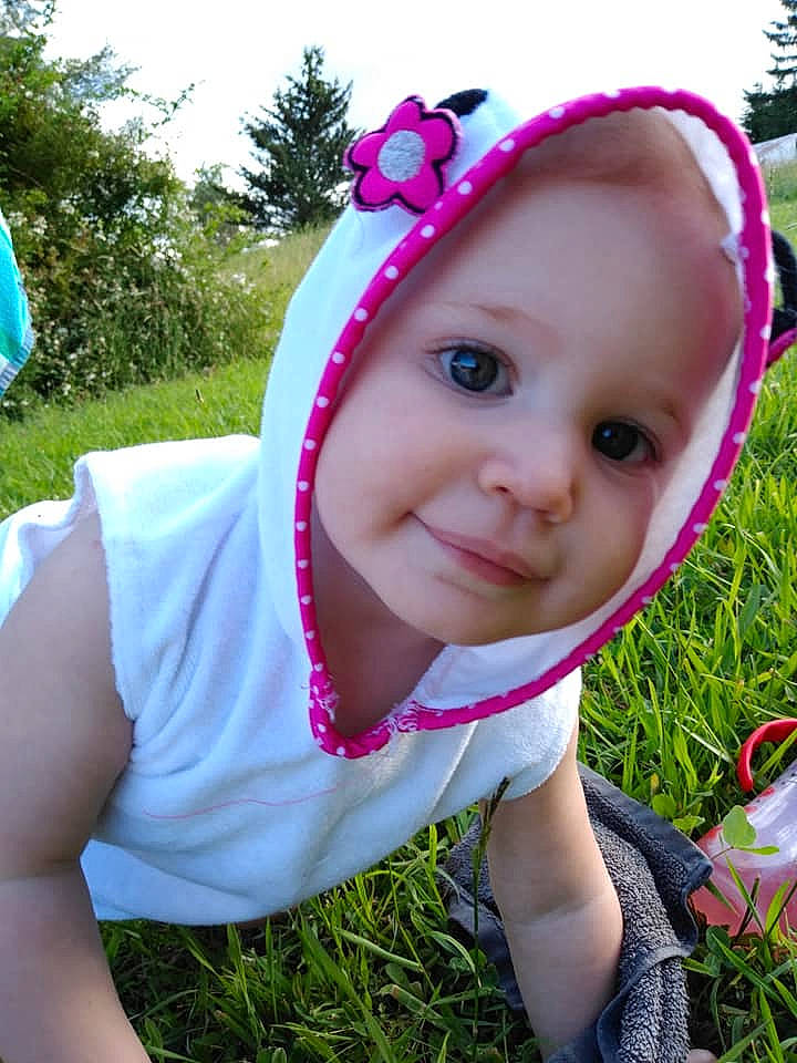 Raevyn is registered to the contest to win money with this photo: baby, baby_toddler_clothing, cheek, child, face, fashion_accessory, fun, grass, hair_accessory, happy, head, headband, headgear, person, pink, plant, purple, skin, smile, summer