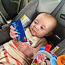 baby, infant, child, car_seat, vehicle, portrait, face, eyes, curious, sitting, clothing, knitwear, blanket, toy, colorful, blue_card, mastercard, indoor, travel, safe