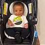 Ayden joined the competition — help win amazing prizes! baby, car_seat, smiling, child, infant, nike_tshirt, black_pants, indoor, wooden_table, striped_pattern, happy, person, cute, seat, headrest, footwear, cushion, safety, wall, floor