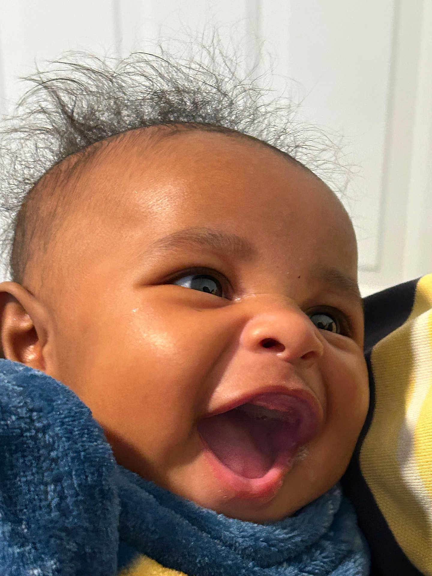 Ayden is registered to the contest to win money with this photo: baby, child, smiling, close_up, face, happy, hair, blanket, mouth_open, skin, infant, person, cute, joy, expression, indoor, cozy, warm, young, portrait