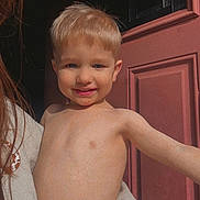 Remmington joined the competition — help win amazing prizes! adult_hand, arm, blond_hair, child, closeup, cute, door, face, happy, holding, indoors, person, portrait, red_door, shirtless, skin, smiling, sunlight, toddler, young_child