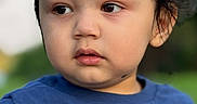 Arshan is registered to the contest to win money with this photo: child, toddler, portrait, face, person, blue_shirt, outdoor, close_up, looking_away, curious, serious, young, head, hair, eyes, nose, mouth, blurred_background, daylight, photography