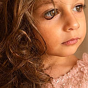 Tima joined the competition — help win amazing prizes! child, girl, portrait, close_up, face, curly_hair, brown_hair, blue_eyes, looking_away, serious_expression, pink_dress, sequins, sparkles, shoulders, indoor, warm_lighting, photography, beauty, young_person, fashion