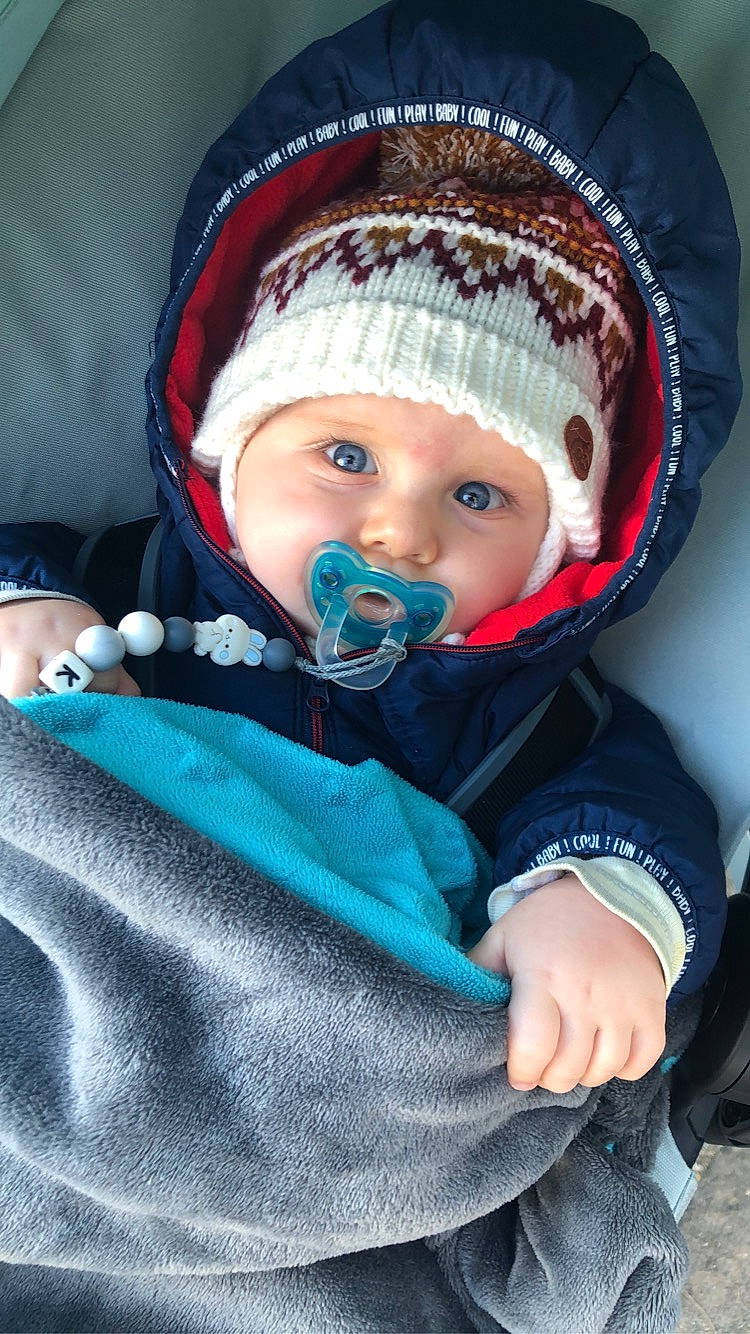 Kayden a rejoint le concours — aidez-le/la à gagner de superbes lots ! baby, baby_carriage, baby_products, baby_toddler_clothing, beanie, cap, cheek, child, comfort, electric_blue, eye, fashion_accessory, freezing, fun, headwear, iris, knit_cap, person, sitting, skin