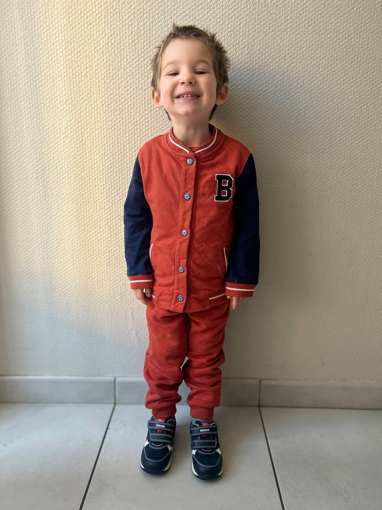 Kelyan participe au concours pour gagner de l'argent avec cette photo : baby_toddler_clothing, child, costume, denim, electric_blue, face, fashion_design, flooring, fun, gesture, human_body, joy, knee, person, personal_protective_equipment, sleeve, smile, t_shirt, toddler, uniform