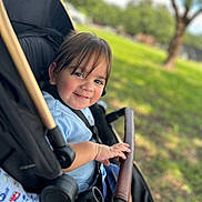 Ezequiel Cortinez joined the competition — help win amazing prizes! toddler, child, smile, stroller, outdoor, park, greenery, sunlight, baby, happy, seatbelt, hand, face, hair, nature, grass, tree, foot, casual_clothing, daytime