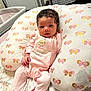 Gianna is registered to the contest to win money with this photo: baby, infant, pink_clothing, slippers, bear_design, pillow, butterfly_pattern, bed, blanket, curly_hair, indoors, cute, child, portrait, resting, soft_lighting, young, person, floor, sleepwear