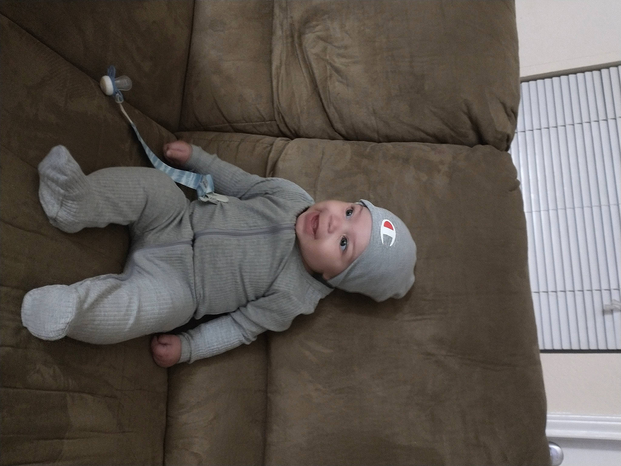 Cashton is registered to the contest to win money with this photo: baby, baby_products, baby_toddler_clothing, bedding, child, comfort, couch, elbow, flooring, grey, headwear, linens, nap, person, room, sitting, sleep, toddler, wood