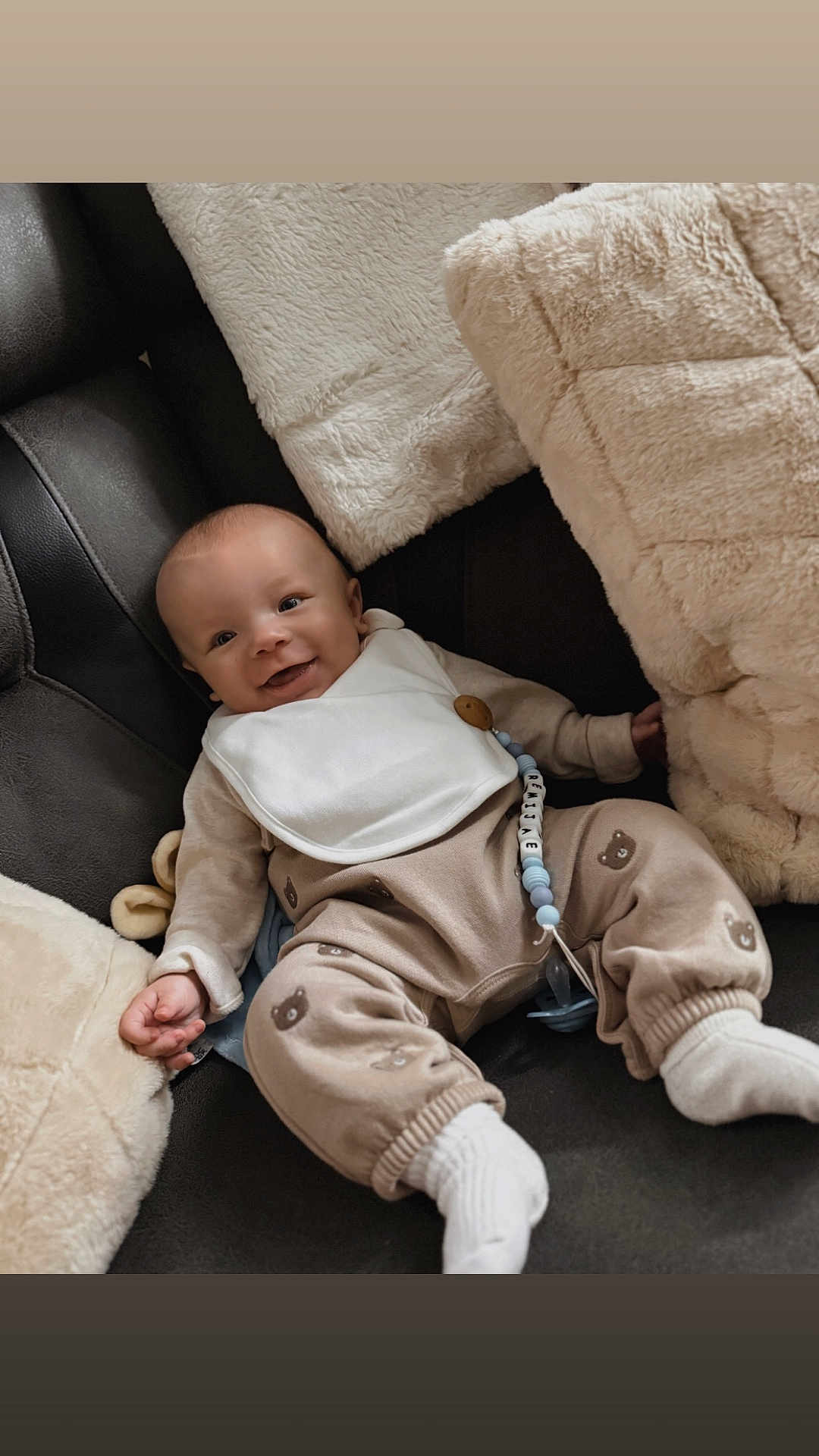 Remi Jae is registered to the contest to win money with this photo: baby, smile, infant, couch, pillow, blanket, cozy, clothing, socks, bib, face, happy, indoors, cute, relaxing, child, soft, comfort, pacifier, toy
