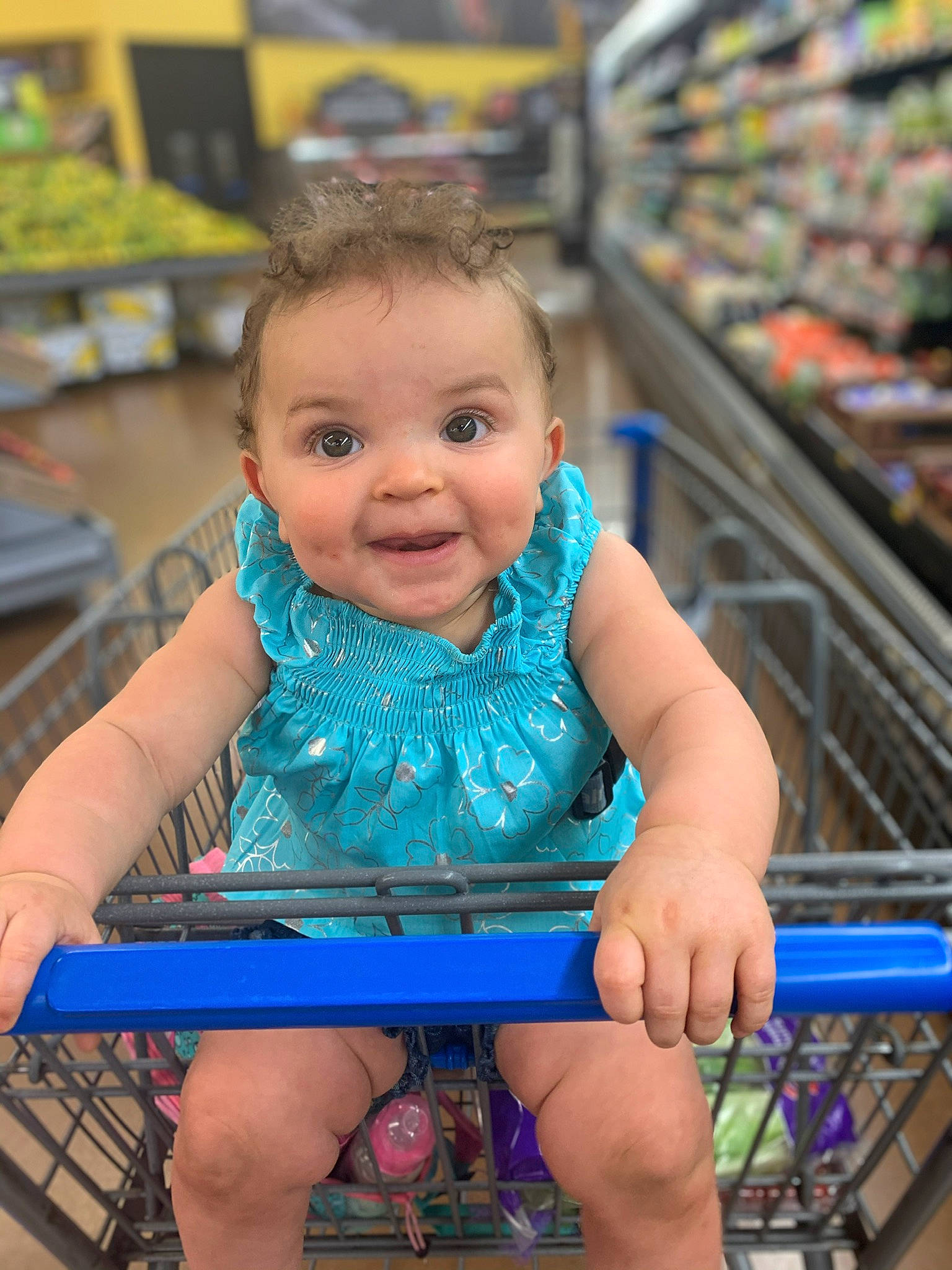 Blakelynn is registered to the contest to win money with this photo: blue, cart, child, fun, grocery_store, leisure, person, retail, shopping_cart, sitting, skin, smile, summer, supermarket, toddler, vacation, vehicle