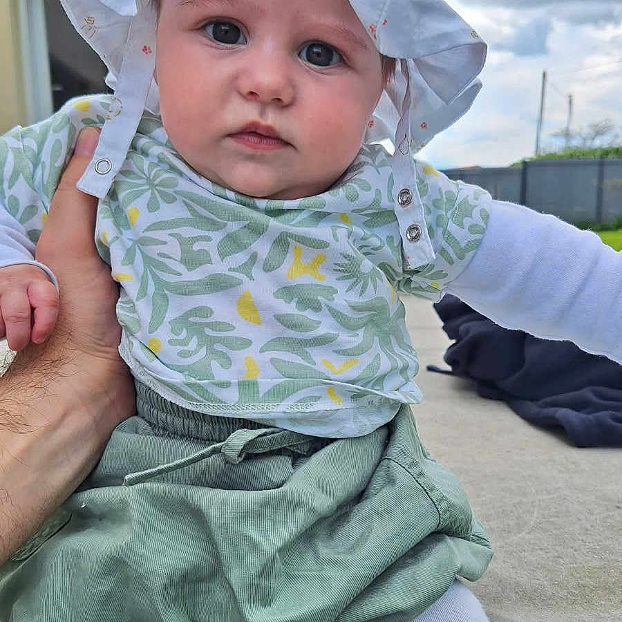 Marie a rejoint le concours — aidez-le/la à gagner de superbes lots ! baby, bonnet, cap, clothing, coat, costume, dress, face, hat, head, hood, jacket, pants, person, photography, portrait, scarf, sitting, sunhat, t_shirt