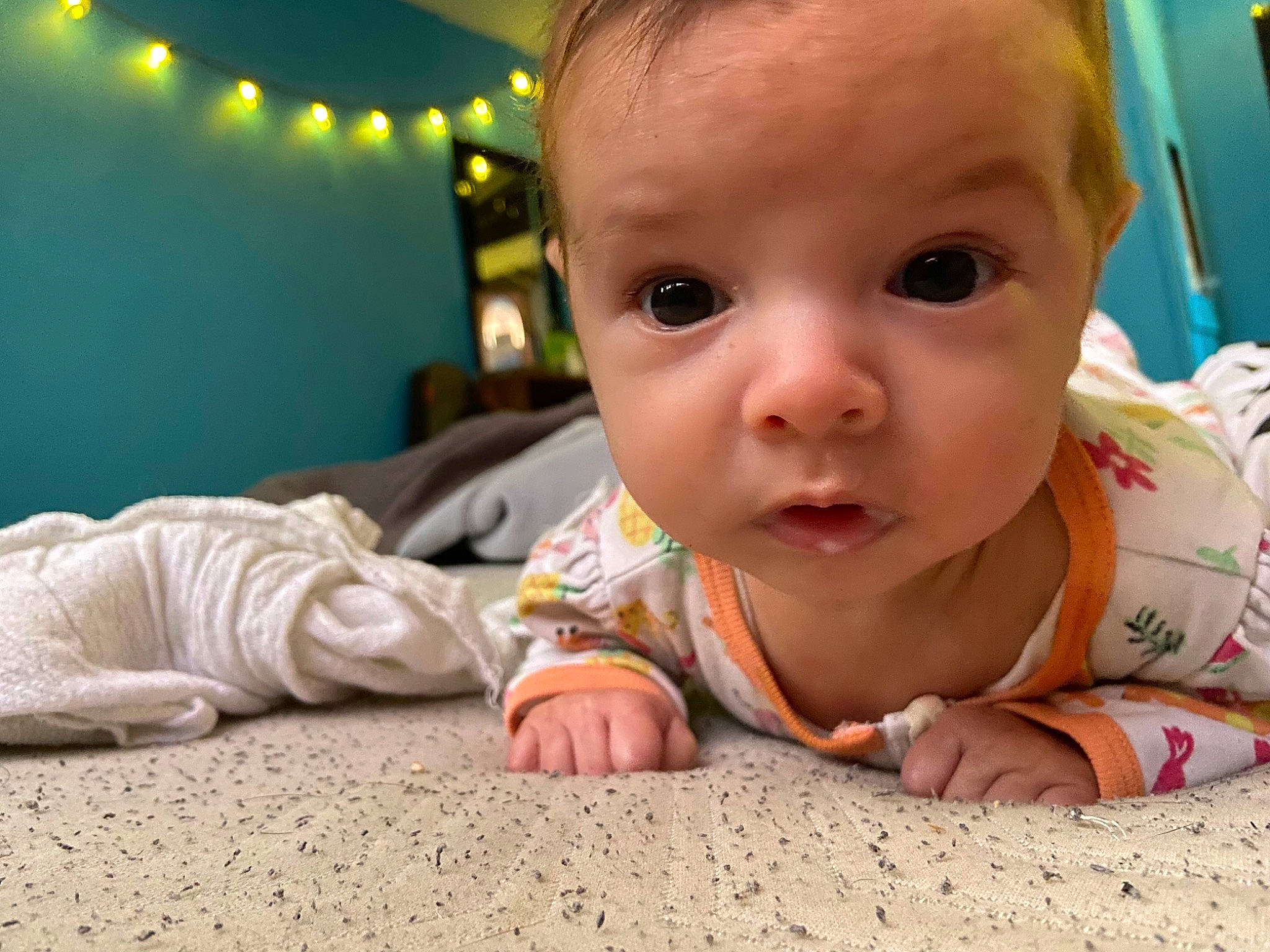 Evie is registered to the contest to win money with this photo: baby, baby_toddler_clothing, cheek, child, chin, comfort, crawling, facial_expression, flooring, fun, happy, iris, lip, mouth, nose, person, sitting, skin, toddler, tummy_time