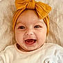 baby, infant, smiling, headband, bow, closeup, face, happy, cute, apparel, blanket, clothing, person, portrait, child, soft, pink, yellow, indoors, expression