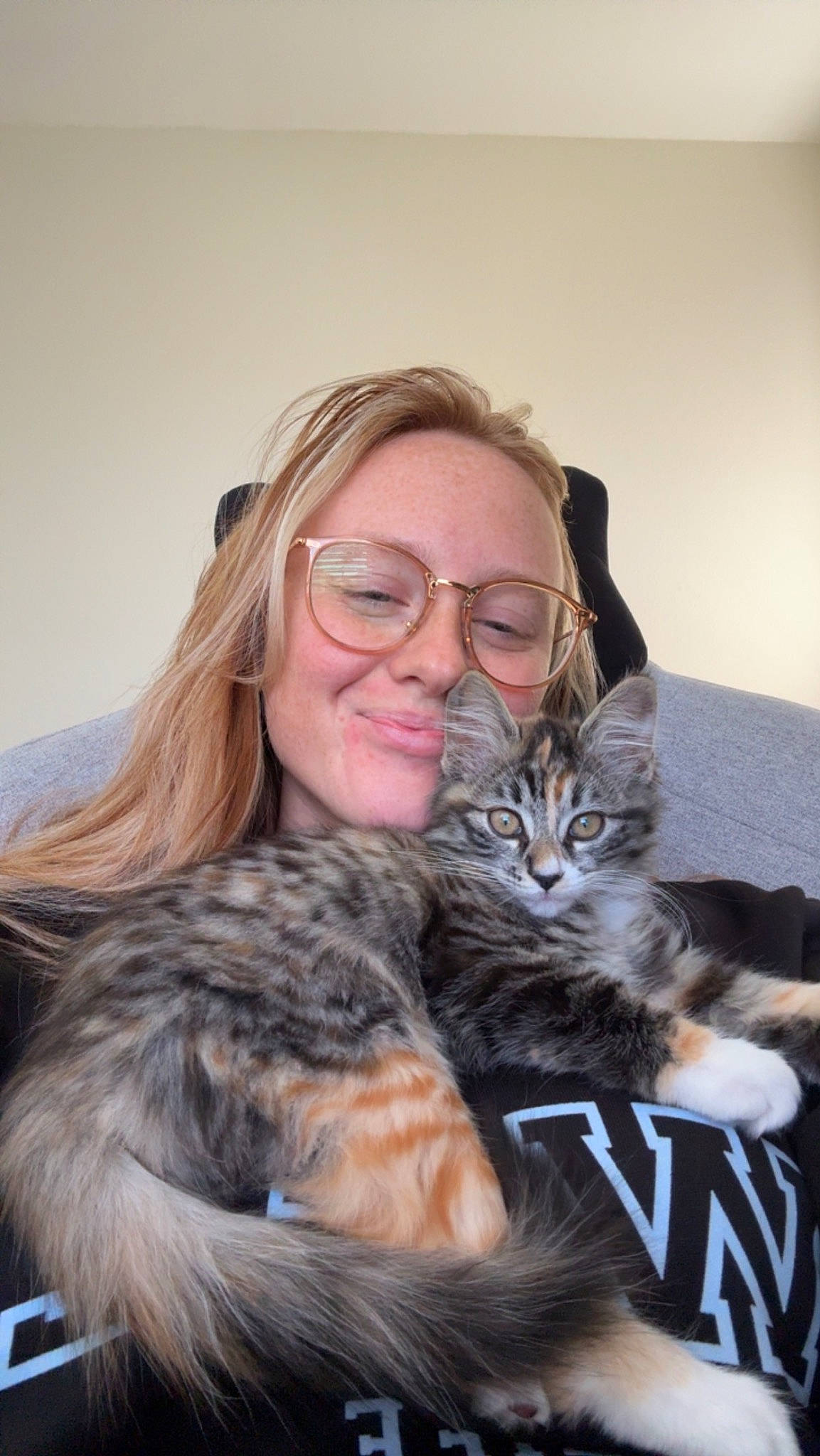 Oneida May is registered to the contest to win money with this photo: carnivore, cat, claw, comfort, companion_dog, couch, domestic_short_haired_cat, eyewear, felidae, fur, glasses, happy, hug, lap, paw, sitting, small_to_medium_sized_cats, smile, whiskers