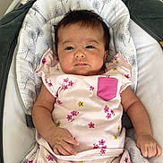 Bala a rejoint le concours — aidez-le/la à gagner de superbes lots ! baby, infant, child, pink_clothing, floral_pattern, baby_rocker, cushion, face, arms, legs, indoor, fabric, soft_texture, cute, resting, newborn, person, sitting, comfortable, expression