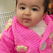 Bala participe au concours pour gagner de l'argent avec cette photo : aisle, baby, button, child, clothing, curious, cute, face, flowers, grocery_store, indoor, infant, knitwear, person, pigtails, pink_sweater, portrait, shopping_cart, supermarket, young_child