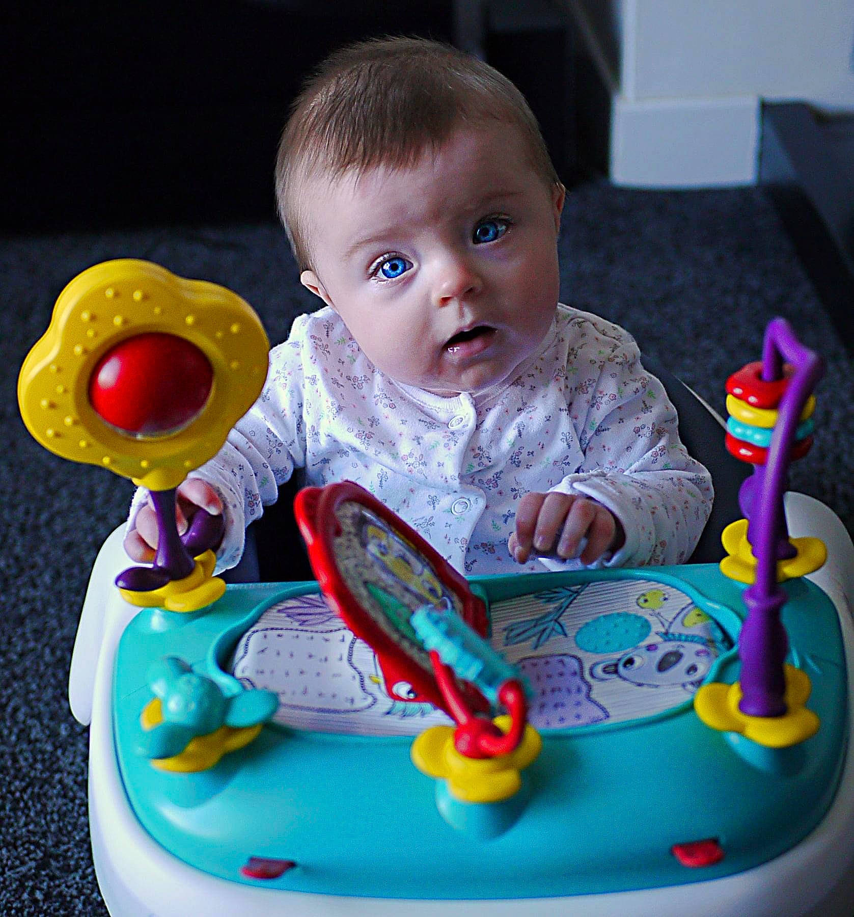 Mila-rose is registered to the contest to win money with this photo: baby, baby_playing_with_toys, baby_products, baby_toddler_clothing, baby_toys, cheek, child, event, facial_expression, fun, green, head, person, play, product, room, sitting, surprise, tableware, toddler