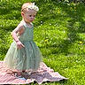 toddler, child, green_dress, headband, blanket, grass, outdoor, nature, flower, sunlight, summer, portrait, young_child, cute, baby_shoes, walking, garden, daylight, innocence, small_child