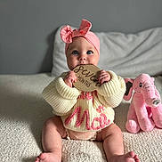 Tatum is registered to the contest to win money with this photo: baby, blanket, bow, child, childhood, cozy, cute, elephant_toy, happy, indoors, infant, knitwear, pink_headband, plush_toy, portrait, seven_months, sitting, soft_texture, sweater, wooden_sign