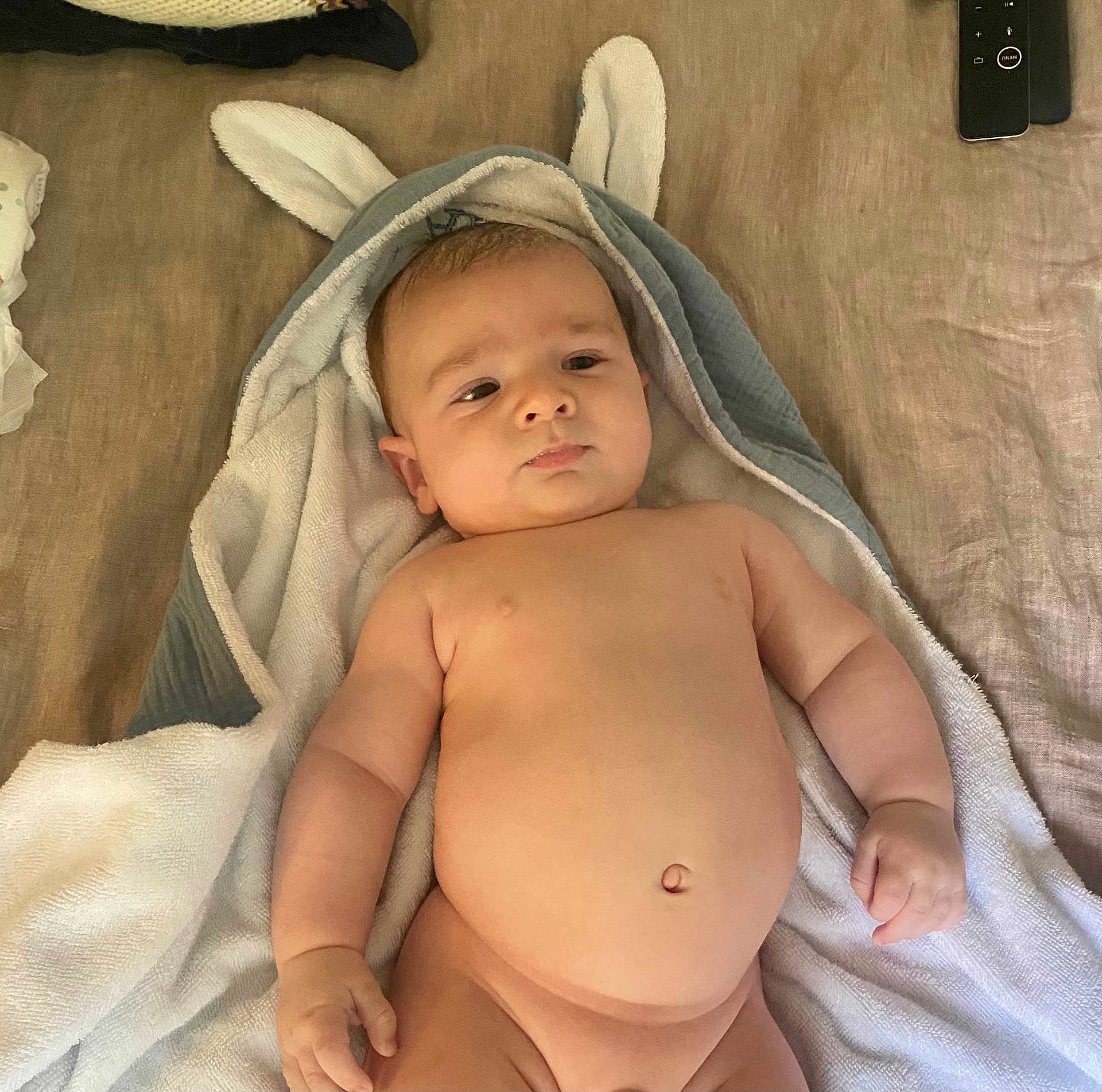 Andrea participe au concours pour gagner de l'argent avec cette photo : baby, infant, towel, bunny_ears, bed, skin, naked, child, cute, sleepy, indoors, soft, blanket, relaxed, newborn, person, laying, chubby, hand, face