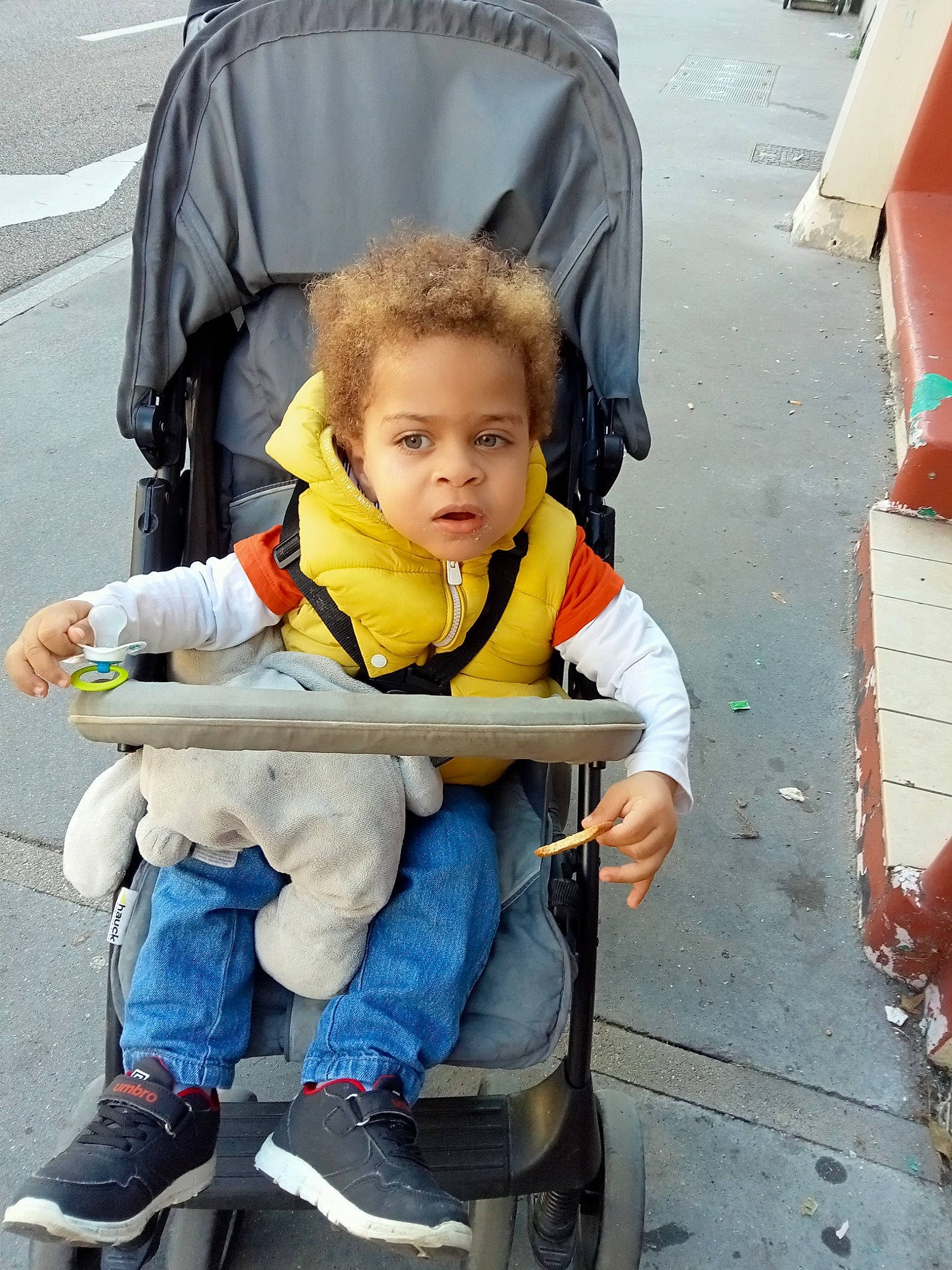 Eliott participe au concours pour gagner de l'argent avec cette photo : asphalt, baby_carriage, baby_products, boot, chair, child, comfort, fun, lap, leisure, person, photograph, public_space, recreation, shoe, sitting, sneakers, tire, toddler, travel