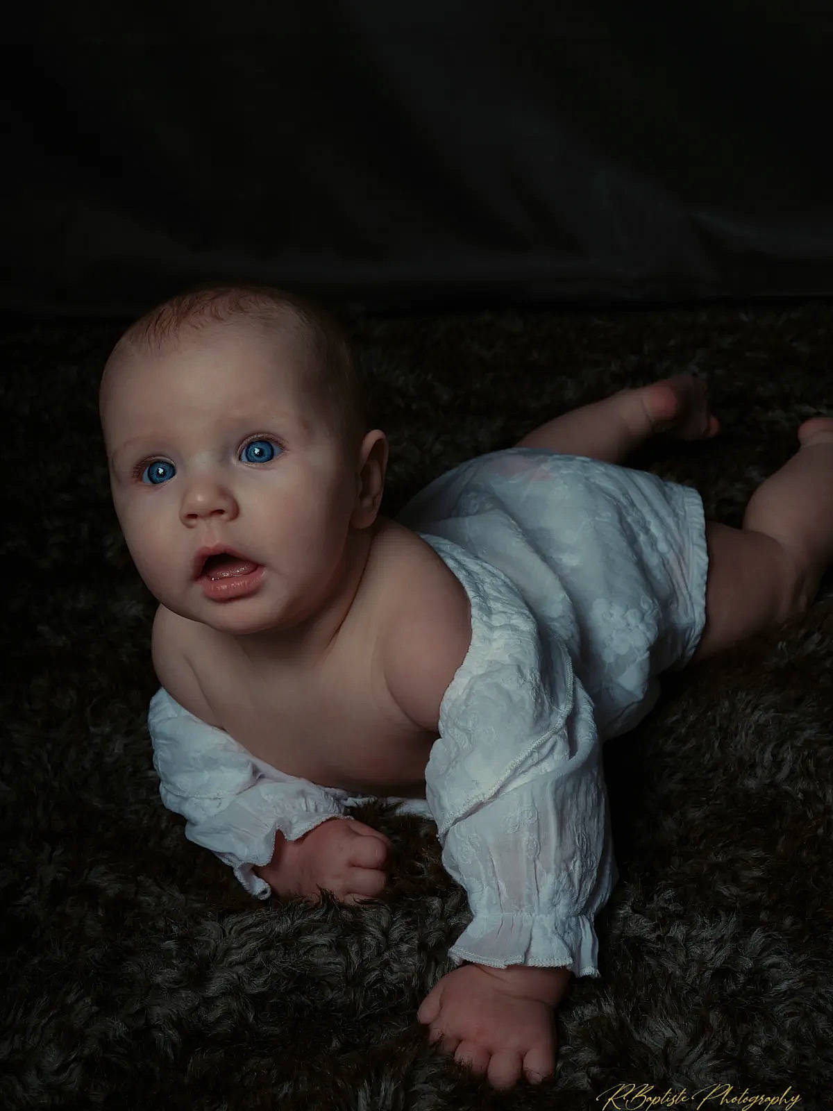 Nora participe au concours pour gagner de l'argent avec cette photo : baby, baby_toddler_clothing, cheek, comfort, darkness, dress, eye, flash_photography, flooring, fun, grass, grey, iris, mouth, nose, person, sitting, skin, sleeve, surprise