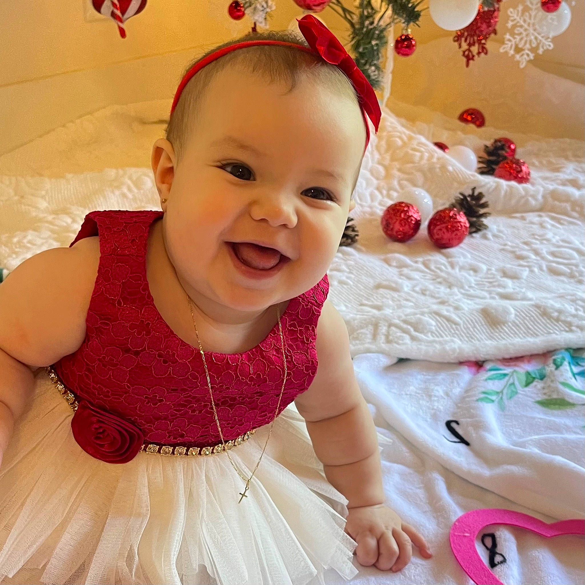 Alice is registered to the contest to win money with this photo: baby, baby_toddler_clothing, child, day_dress, dress, embellishment, event, fashion_accessory, hair_accessory, happy, headpiece, magenta, pattern, peach, person, pink, skin, sleeve, smile, textile