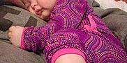 Grace is registered to the contest to win money with this photo: baby, sleeping, onesie, purple, patterned_clothing, pillow, blanket, cozy, indoor, infant, resting, child, cute, soft, comfort, peaceful, toddler, nap, wearing, person