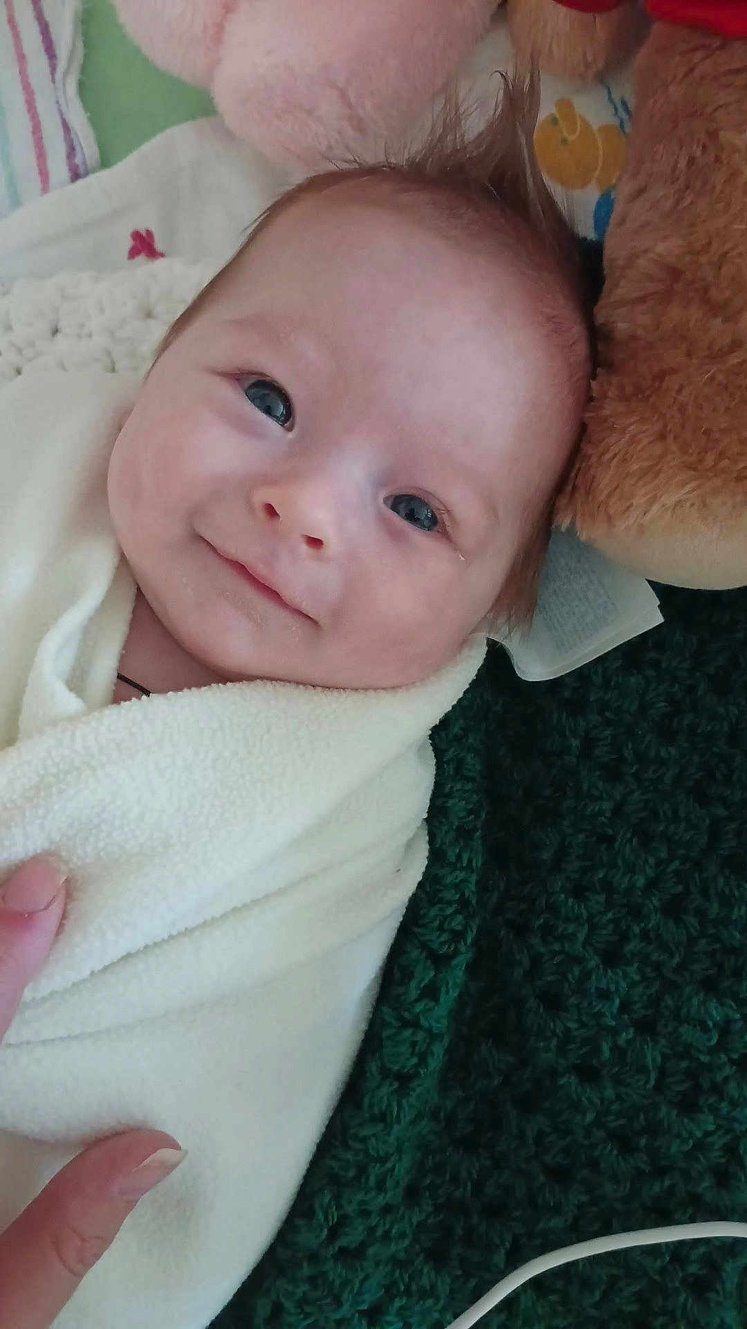 Grace is registered to the contest to win money with this photo: baby, infant, smile, blanket, wrapped, teddy_bear, plush_toy, hand, face, blue_eyes, soft_texture, cozy, cute, indoor, portrait, young_child, newborn, expression, lying_down, warm