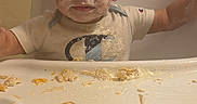 Dylan Jr joined the competition — help win amazing prizes! baby, toddler, child, high_chair, eating, food, messy, face, smile, portrait, indoors, kitchen, window, blinds, short_hair, food_on_face, tray, meal, sitting, happy