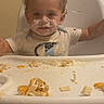 baby, toddler, child, high_chair, eating, food, messy, face, smile, portrait, indoors, kitchen, window, blinds, short_hair, food_on_face, tray, meal, sitting, happy
