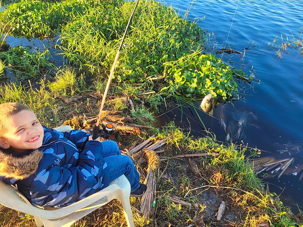 Joseph is registered to the contest to win money with this photo: electric_blue, grass, grass_family, happy, joy, lake, landscape, leaf, leisure, natural_landscape, ocean, people_in_nature, person, plant, recreation, rock, shrub, sitting, water, wilderness