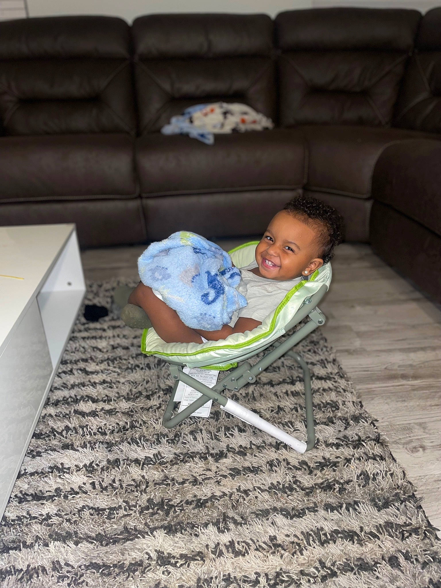 Euro is registered to the contest to win money with this photo: baby, baby_toddler_clothing, carpet, child, comfort, couch, floor, flooring, hardwood, head, joy, linens, living_room, person, rectangle, room, sitting, sofa_bed, studio_couch, throw_pillow