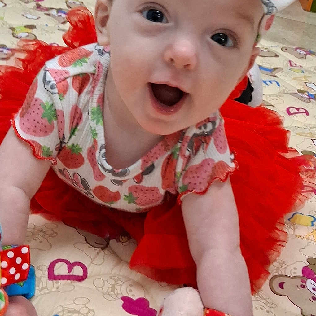 Nevaeh is registered to the contest to win money with this photo: applique, baby, bodypart, bonnet, clothing, crawling, dress, face, finger, hand, hat, head, hosiery, pattern, person, photography, portrait, quilt, sitting, sock