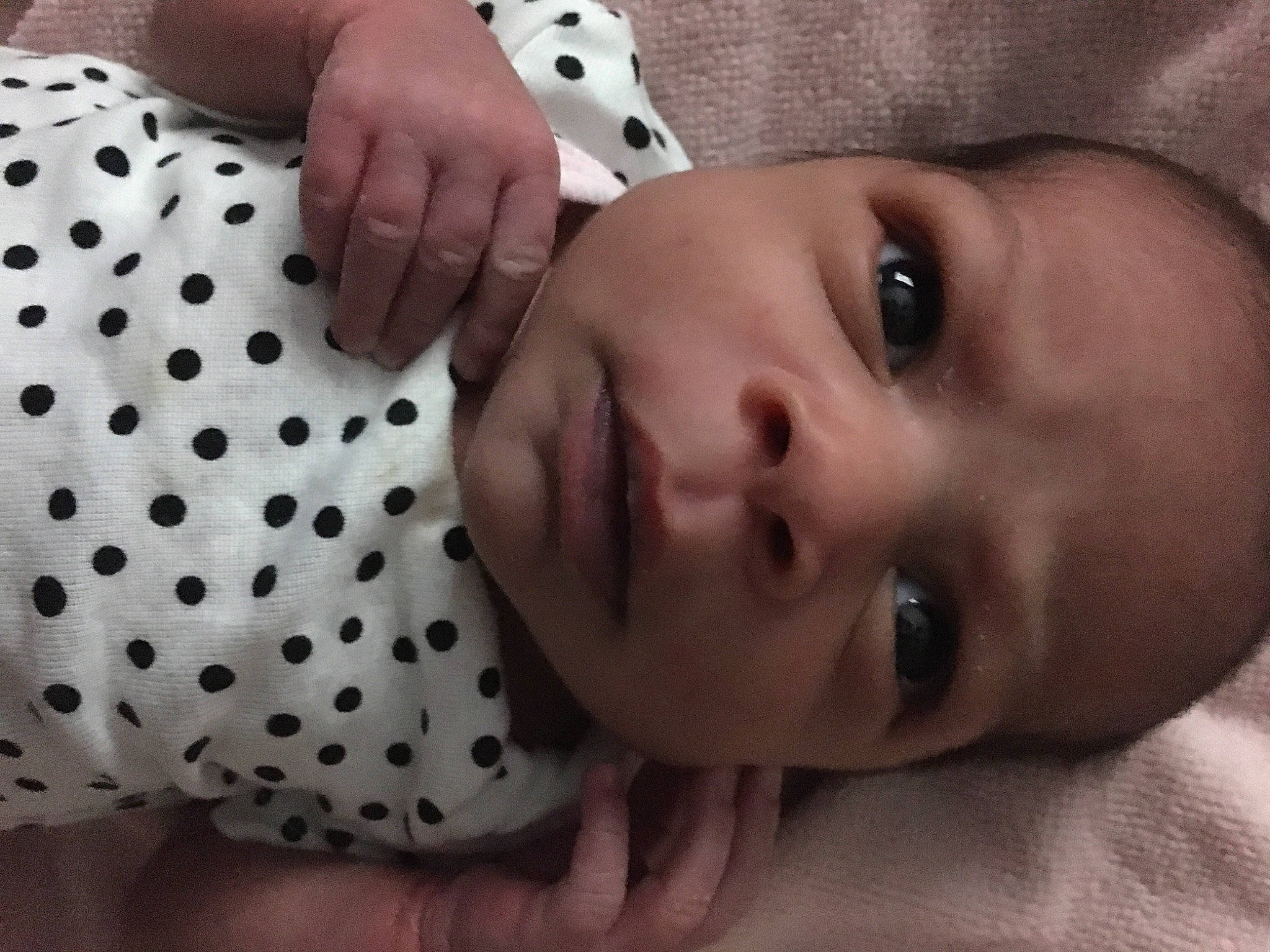 Maria is registered to the contest to win money with this photo: baby, baby_toddler_clothing, black, cheek, eyelash, finger, gesture, hand, human_body, lip, nail, nose, organ, pattern, person, photograph, skin, sleeve, textile, toddler