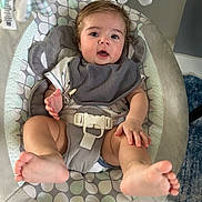 Killian joined the competition — help win amazing prizes! baby, infant, baby_rocker, bib, onesie, feet, face, hand, cushion, pattern, indoor, carpet, toy, seat, child, person, expression, looking, comfort, cute