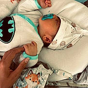 Roméo participe au concours pour gagner de l'argent avec cette photo : animal_print, baby, batman_logo, bed, blanket, clothing, crib, cute, fox, hand, hat, infant, newborn, nursery, pacifier, person, rest, sleeping, soft_toys, tenderness