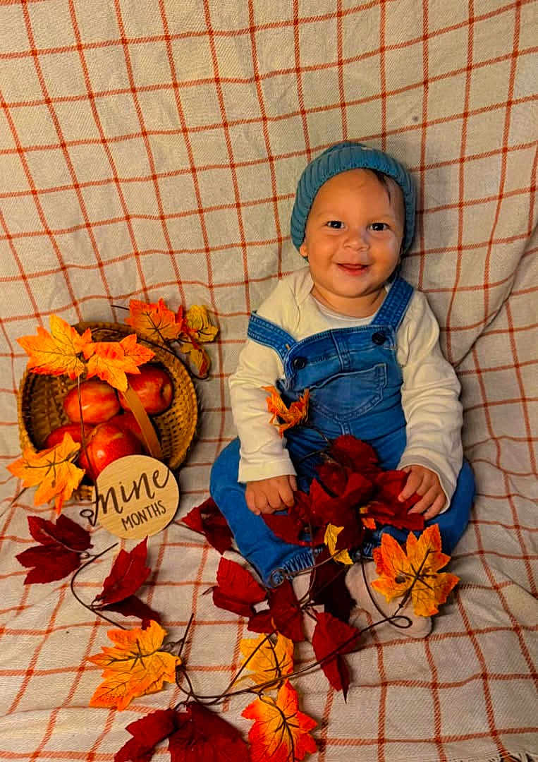 Darryn joined the competition — help win amazing prizes! baby, child, smiling, plaid_blanket, denim_overalls, knit_hat, autumn_leaves, basket, apples, milestone_sign, nine_months, fall_theme, sitting, indoor, portrait, happy, cute, seasonal, decor, baby_photography
