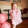 toddler, child, girl, pink_dress, pigtails, smiling, balloons, indoor, floor, shoes, socks, happy, portrait, playing, celebration, room, furniture, wall_art, radiator, cute