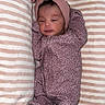newborn, baby, infant, child, portrait, lying_down, striped_blanket, pink, headband, bow, onesie, sleeping, awake, face, eyes, indoors, cozy, textile, cute, photography