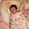 newborn, baby, sleeping, infant, portrait, blanket, swaddle, plush_toy, bunny, nursery, milestone, one_week, cozy, indoors, soft_lighting, pink, beige, floral, wooden_sign, peaceful