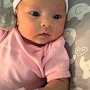 Norrakkesa is registered to the contest to win money with this photo: baby, infant, pink_clothing, hat, mittens, elephant_pattern, cushion, blanket, face, portrait, newborn, child, cute, indoor, resting, soft_texture, cozy, looking_away, closeup, young_child