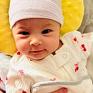 Norrakkesa is registered to the contest to win money with this photo: baby, blanket, cherry_pattern, child, closeup, cute, face, hand, hat, infant, newborn, onesie, person, pillow, portrait, red, sleepwear, soft_texture, white, yellow