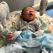 Nyairr is registered to the contest to win money with this photo: architecture, baby, bed, blanket, building, clothing, crib, cushion, face, furniture, glove, head, homedecor, hospital, infantbed, newborn, person, photography, portrait, quilt