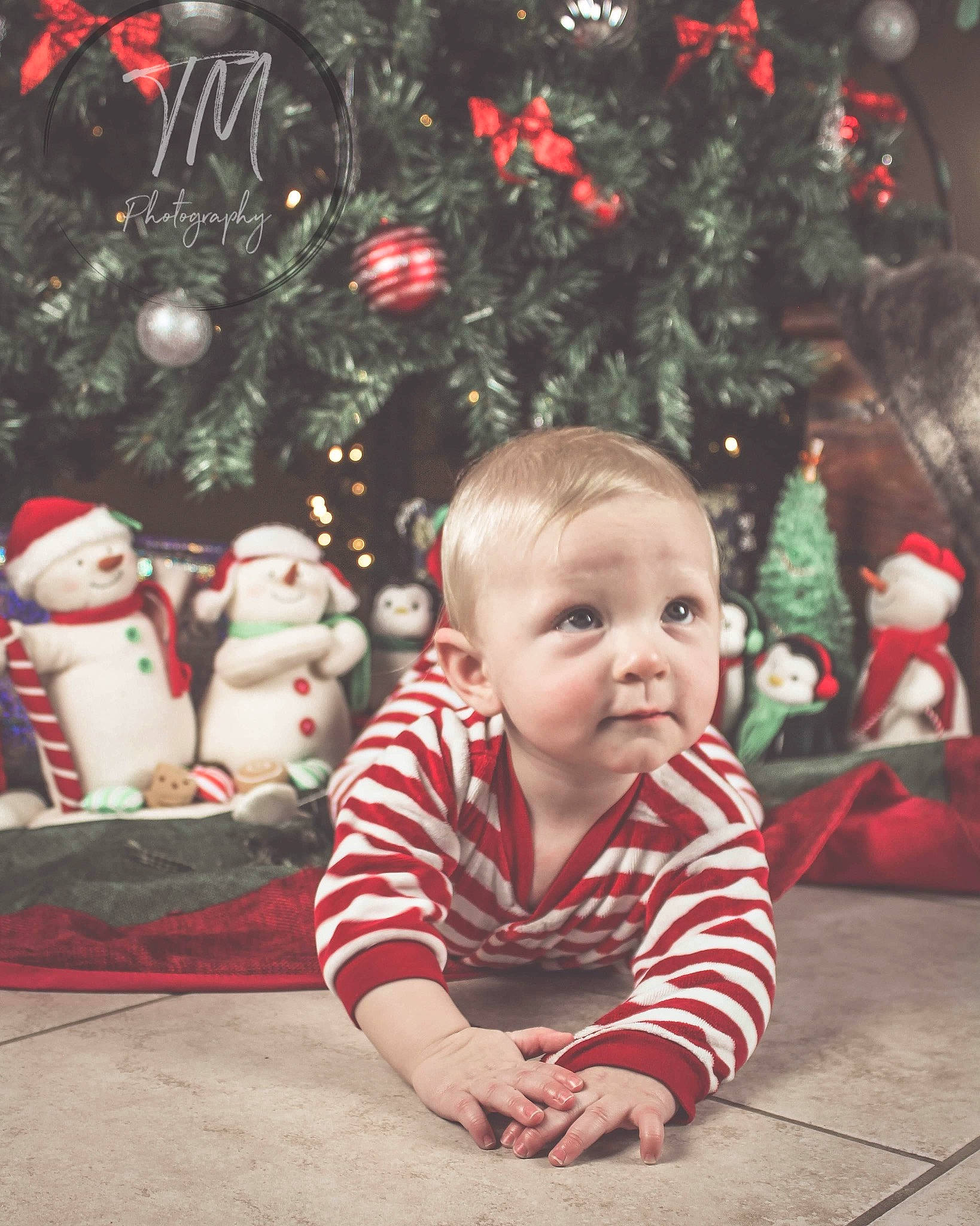 Mackinnon is registered to the contest to win money with this photo: baby, child, christmas, christmas_eve, christmas_ornament, christmas_tree, event, fictional_character, holiday, person, photography, plant, smile, toddler, tree