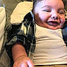 Eric joined the competition — help win amazing prizes! baby, smiling, child, plaid_shirt, white_tshirt, hand, face, happy, infant, portrait, clothing, cute, closeup, indoor, couch, fabric, skin, person, young, relaxed